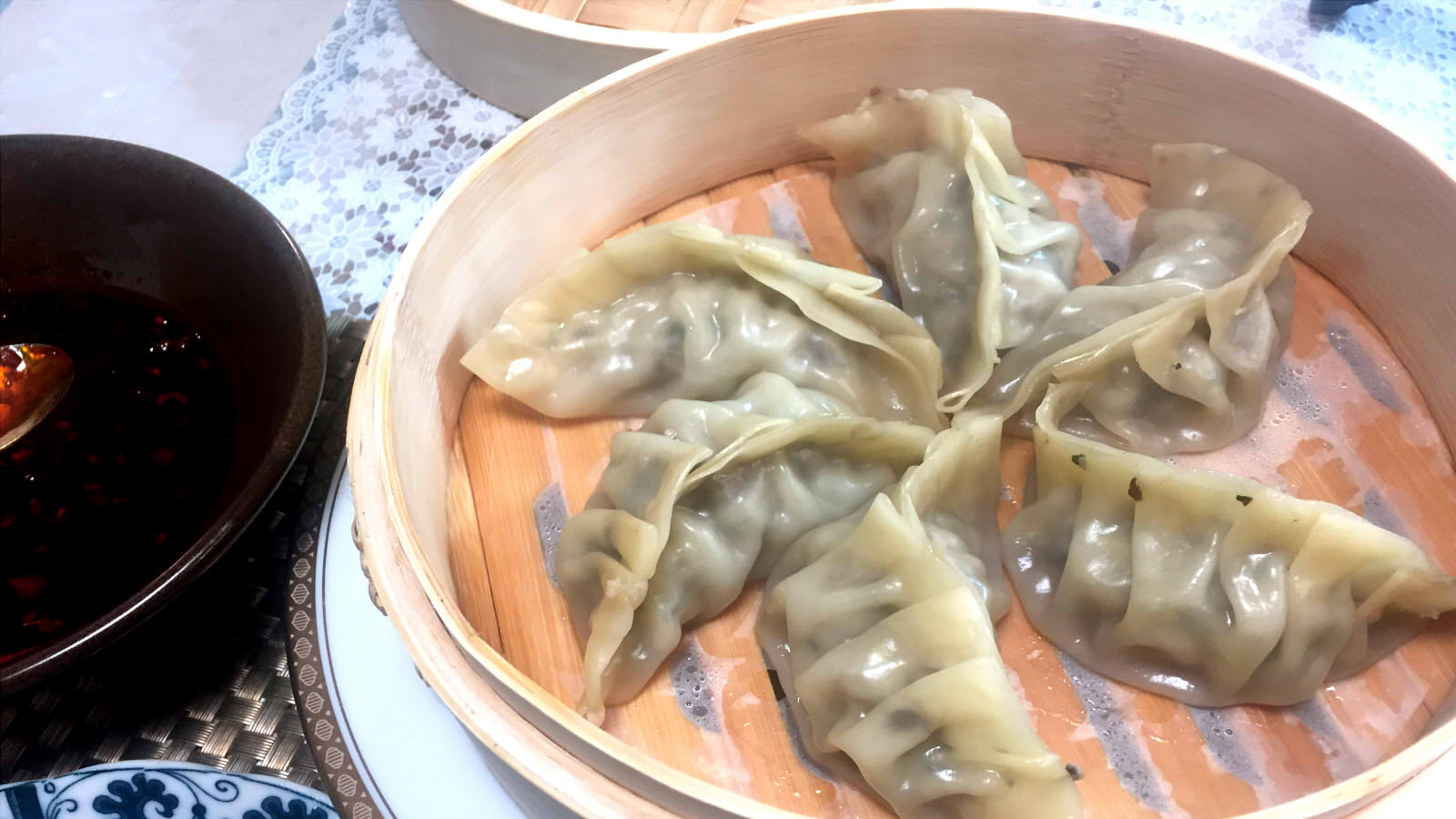 Steamed pork gyoza topped with spicy Szechuan red oil sauce and crushed cashews